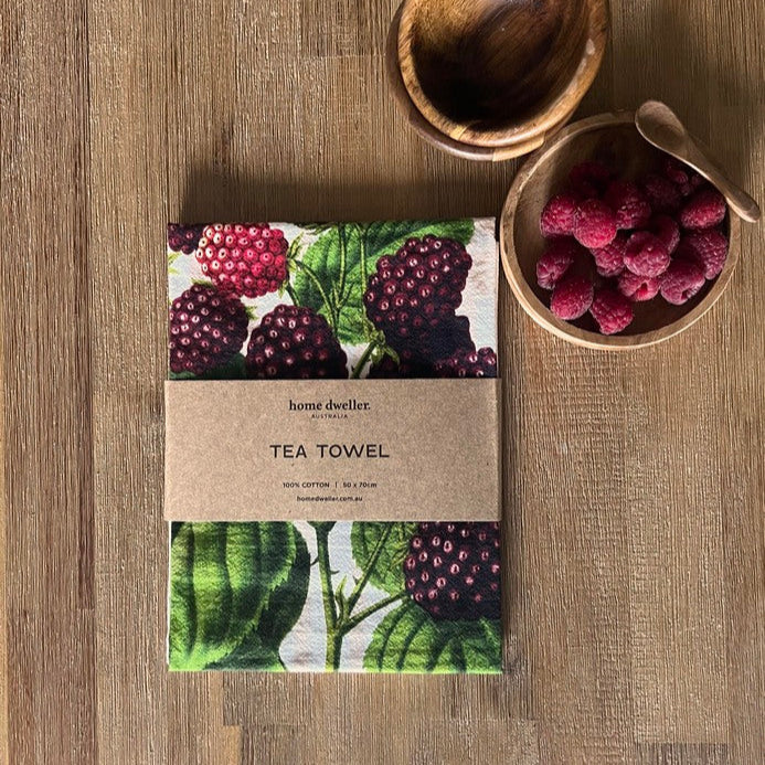 Home Dweller botanical tea towel styled in kitchen with wooden utensils