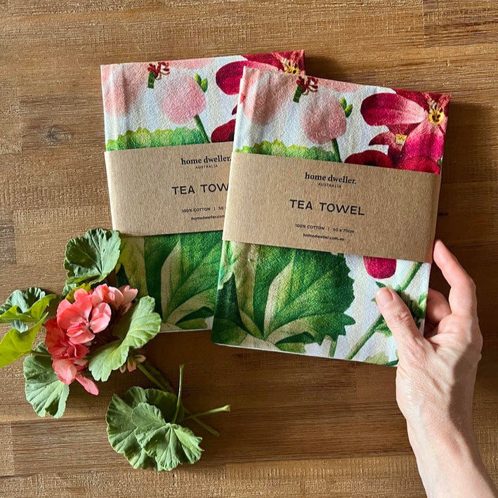 Cotton art tea towel with vintage botanical design folded on kitchen bench