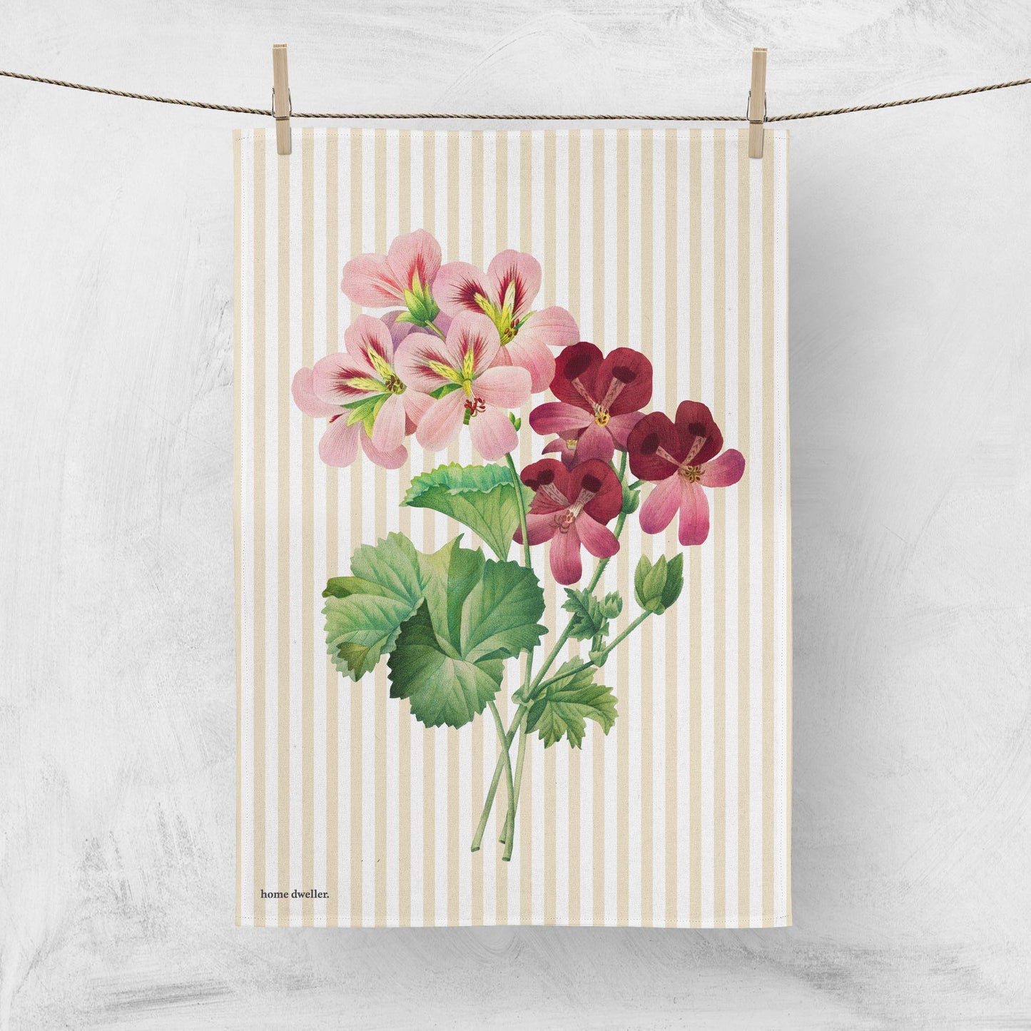Geranium art tea towel with vintage botanical design hanging on line