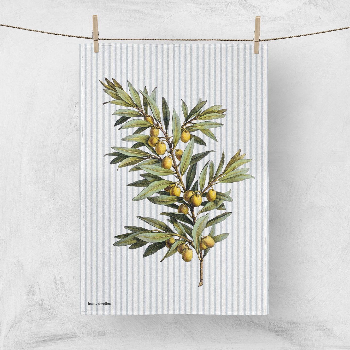 Cotton art tea towel with olive botanical design hanging on clothes line