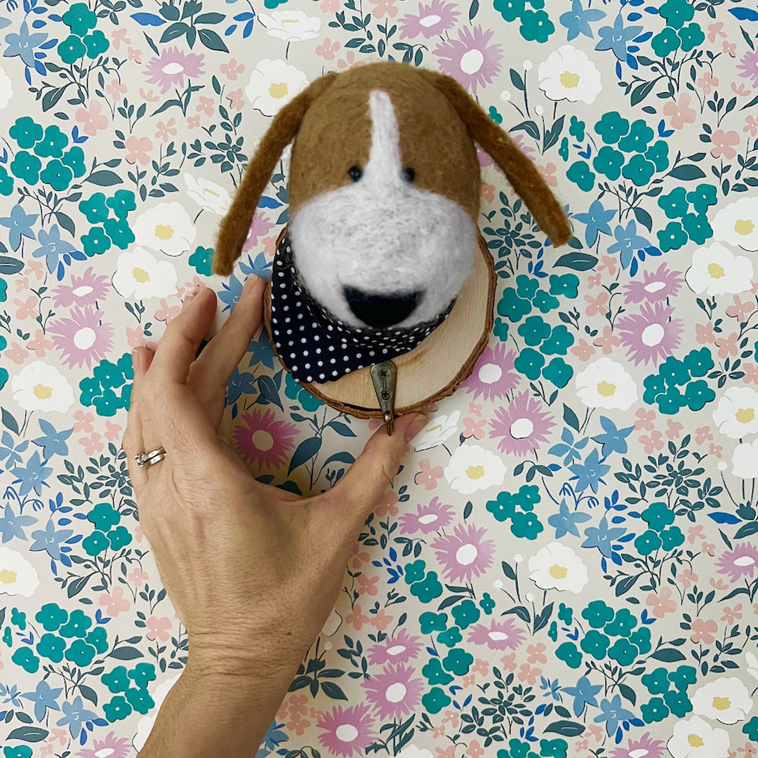Close-up of felt dog face with hand-felted wool texture and brass hook