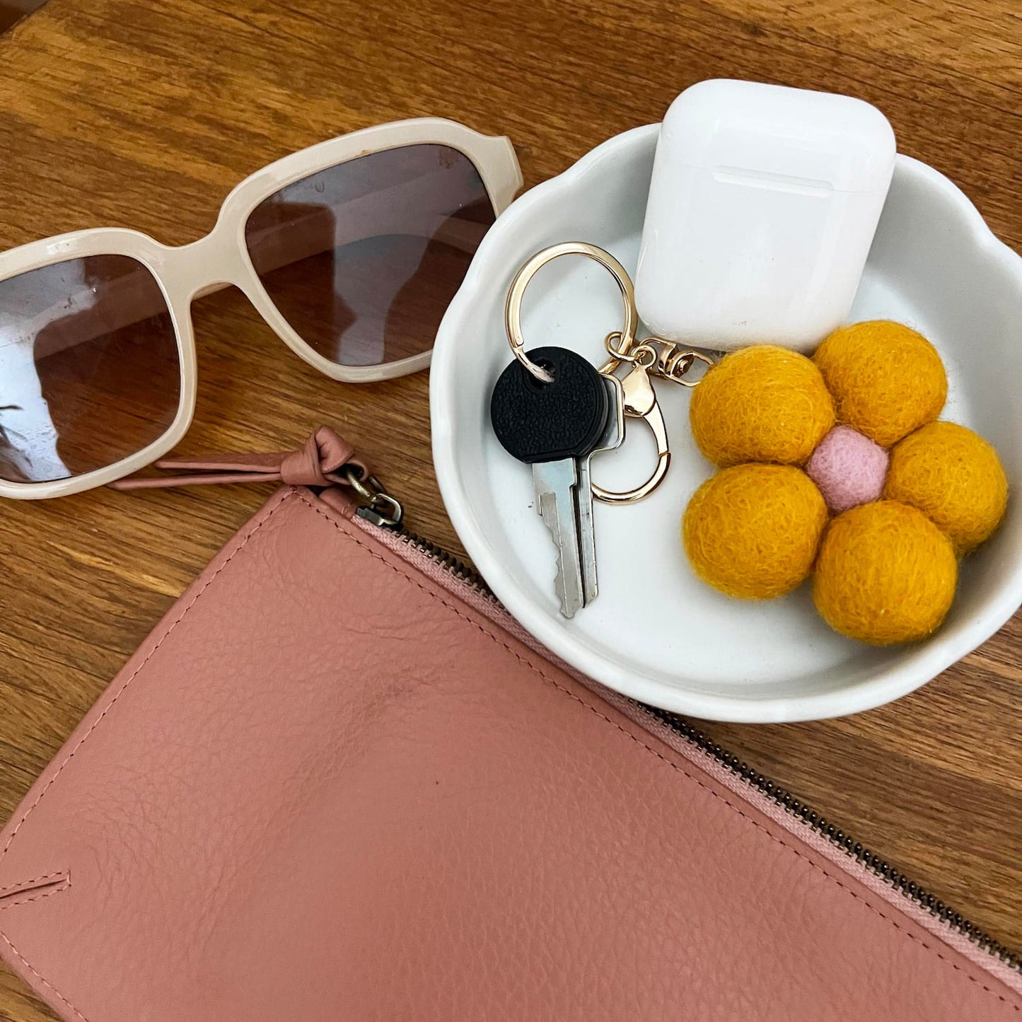 Handmade felt keychain displayed on table with bag accessories
