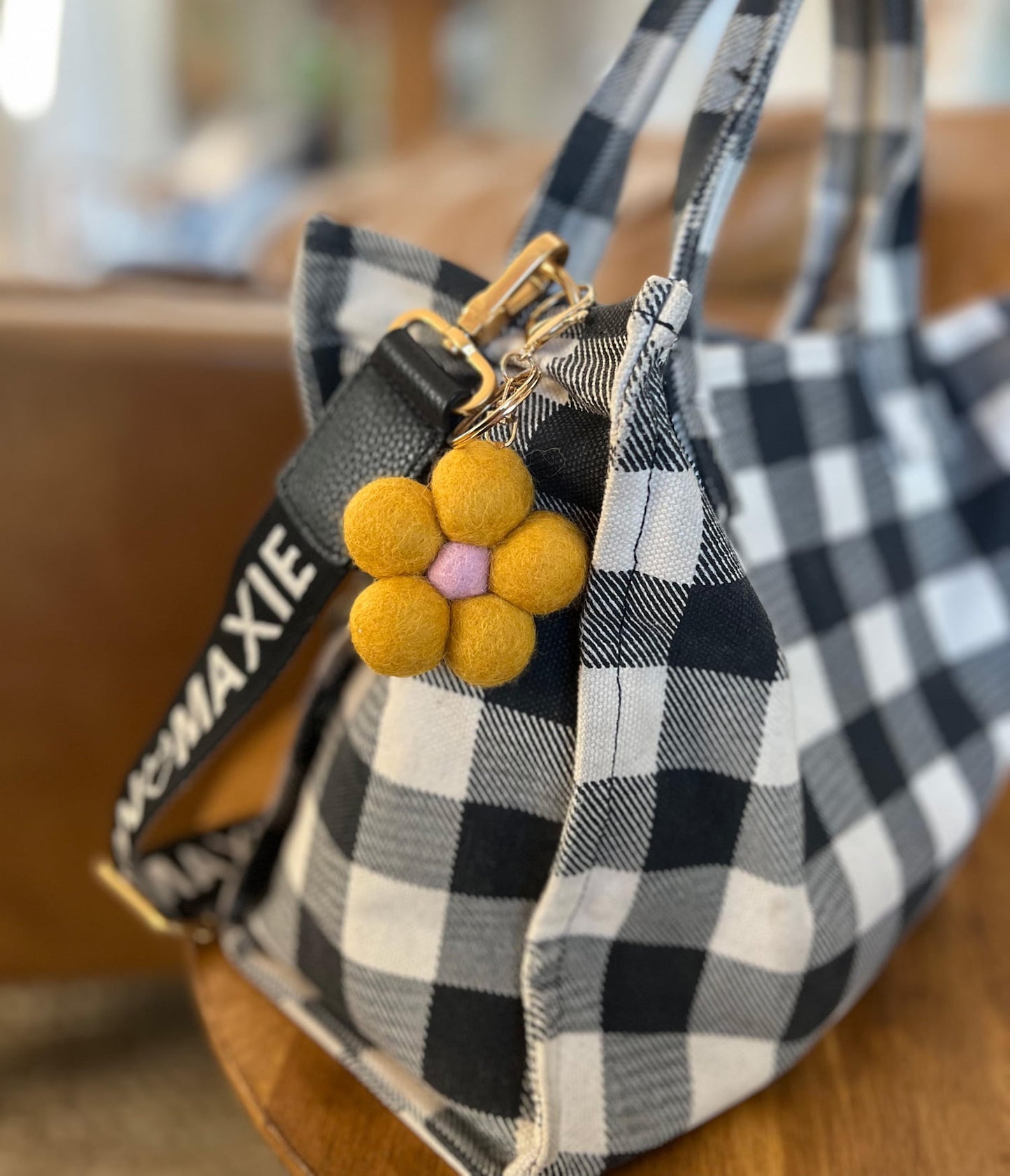 Felt flower keychain clipped to handbag as a bag charm