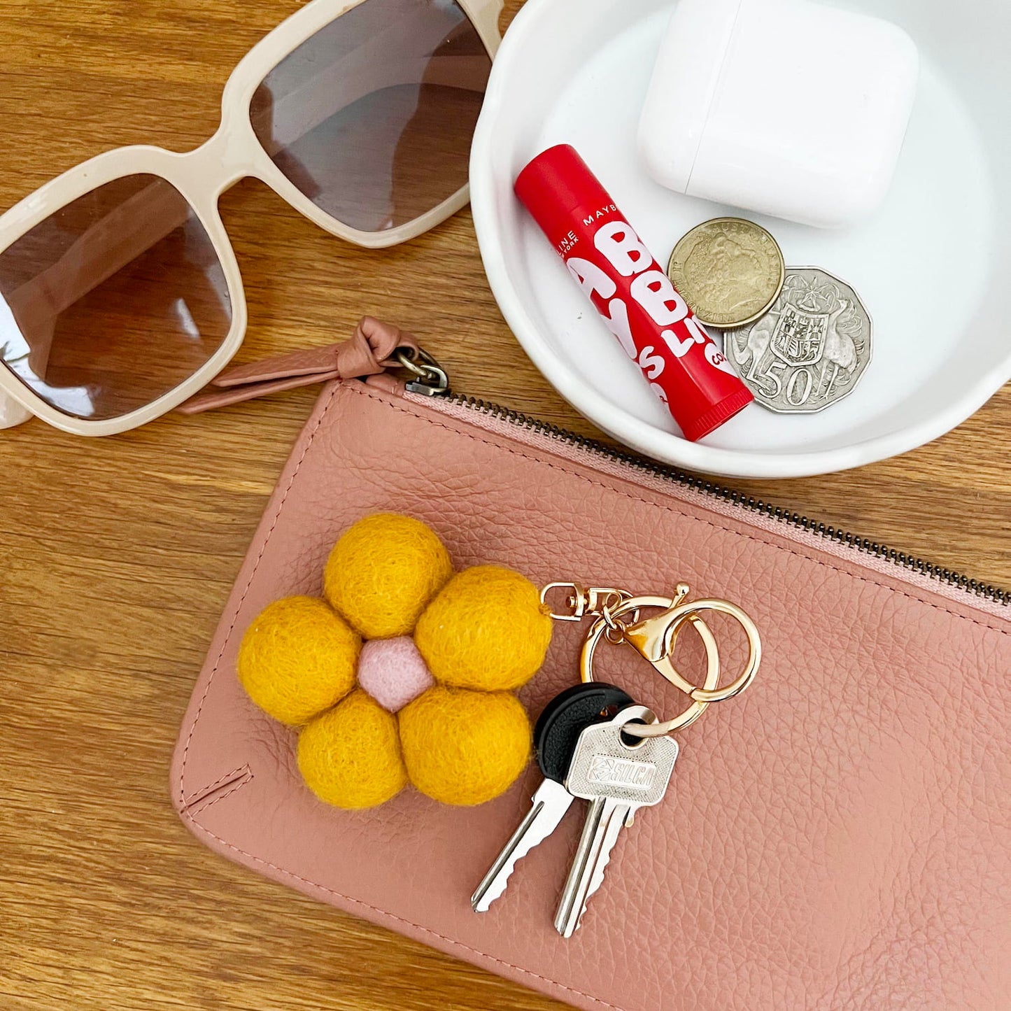 Flower keychain accessory styled on leather pouch