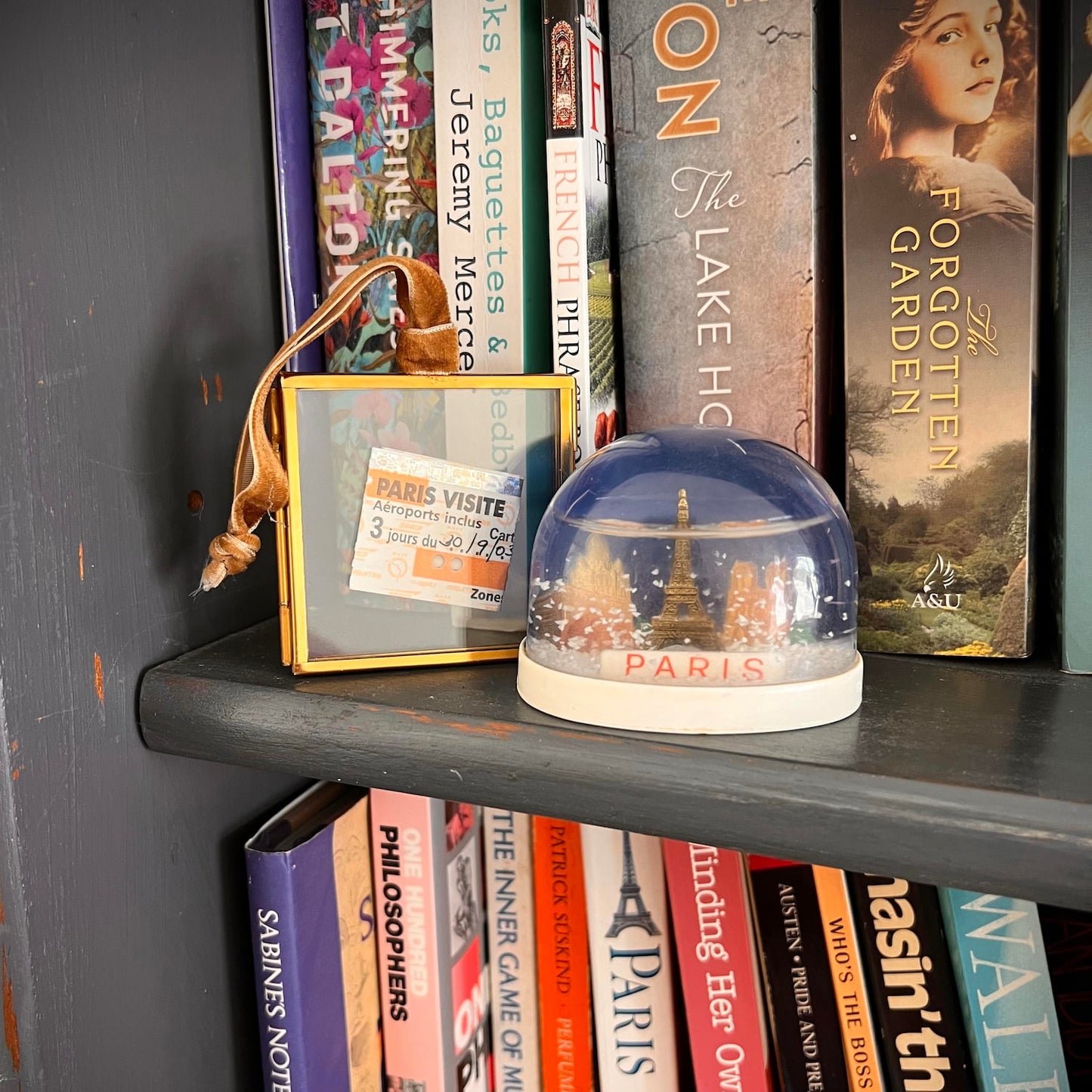 Tiny ticket stub inside glass and brass frame on the shelf