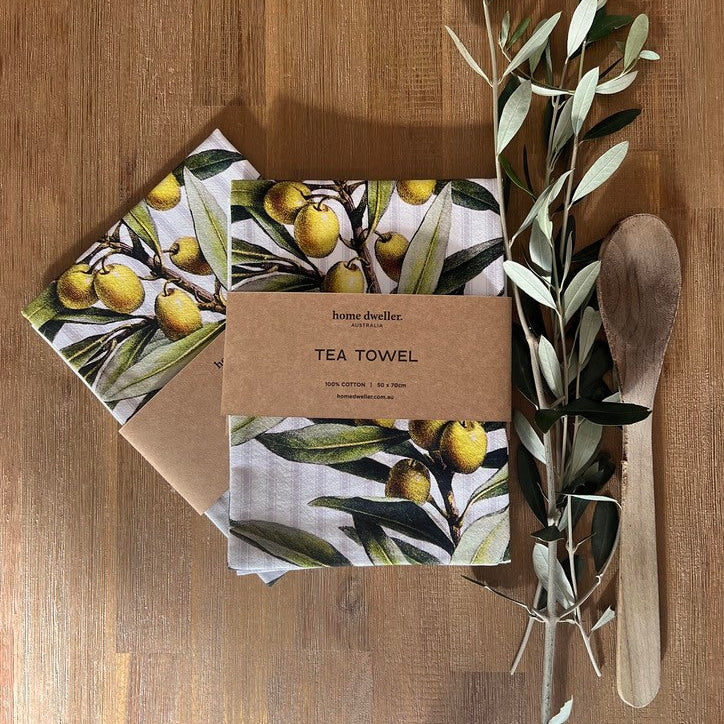 Cotton art tea towel with vintage botanical design folded on kitchen bench