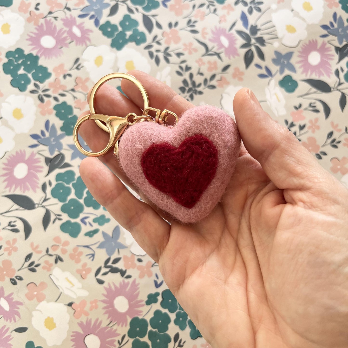 Close-up of handmade felt heart charm in soft pink