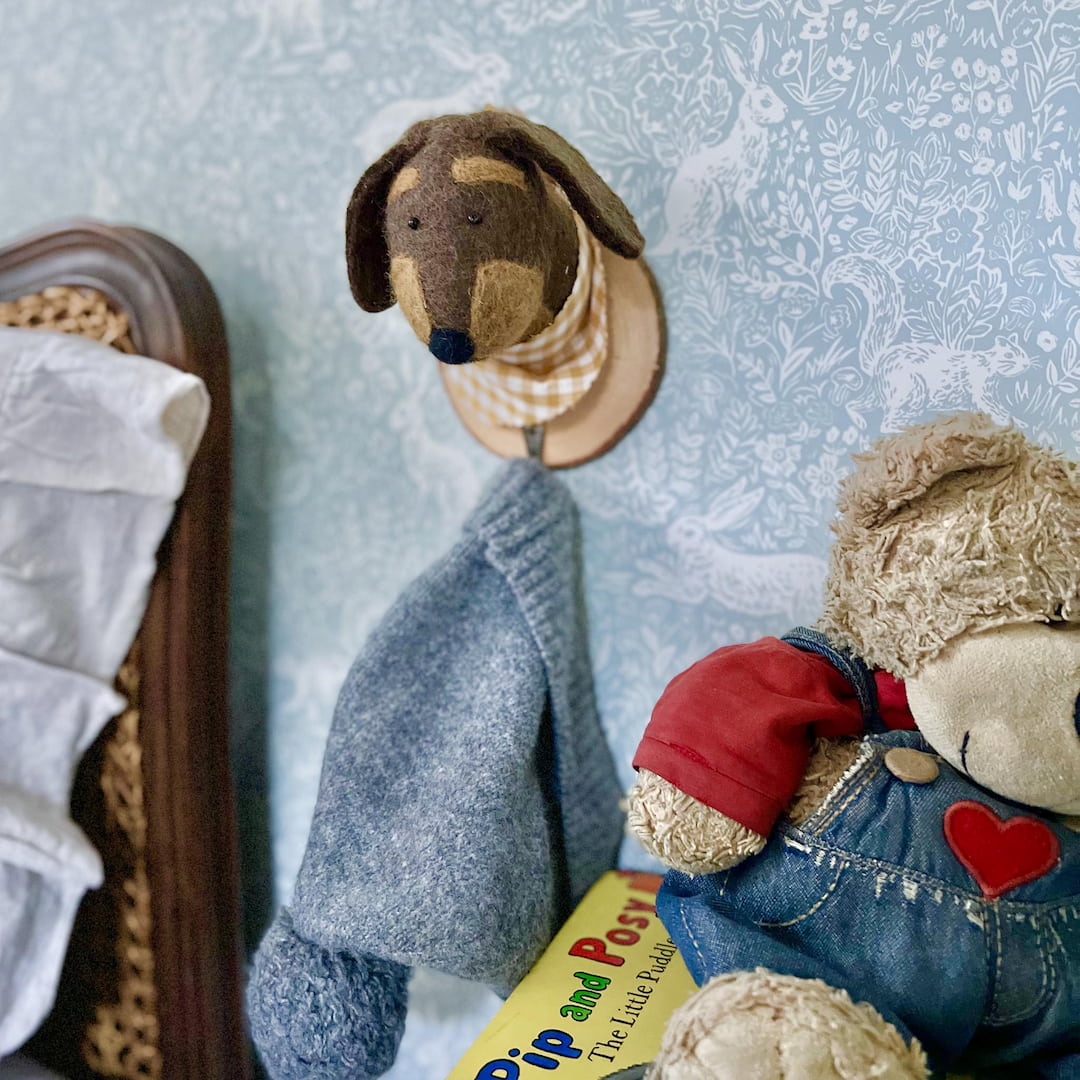 Dog wall hook holding beanie in kids room