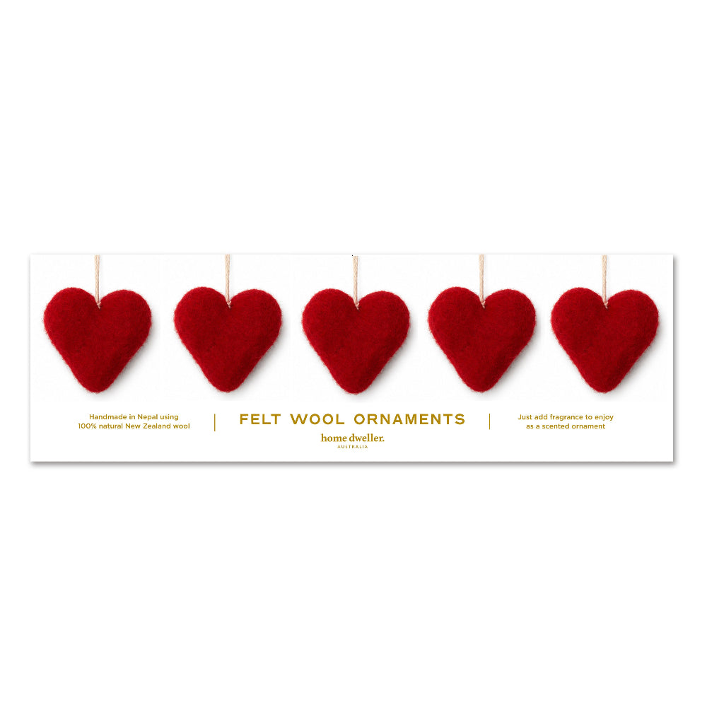 A white rectangular product card displaying five red felt wool heart ornaments hanging by thin strings, with gold text reading 'FELT WOOL ORNAMENTS' and smaller descriptive copy below.