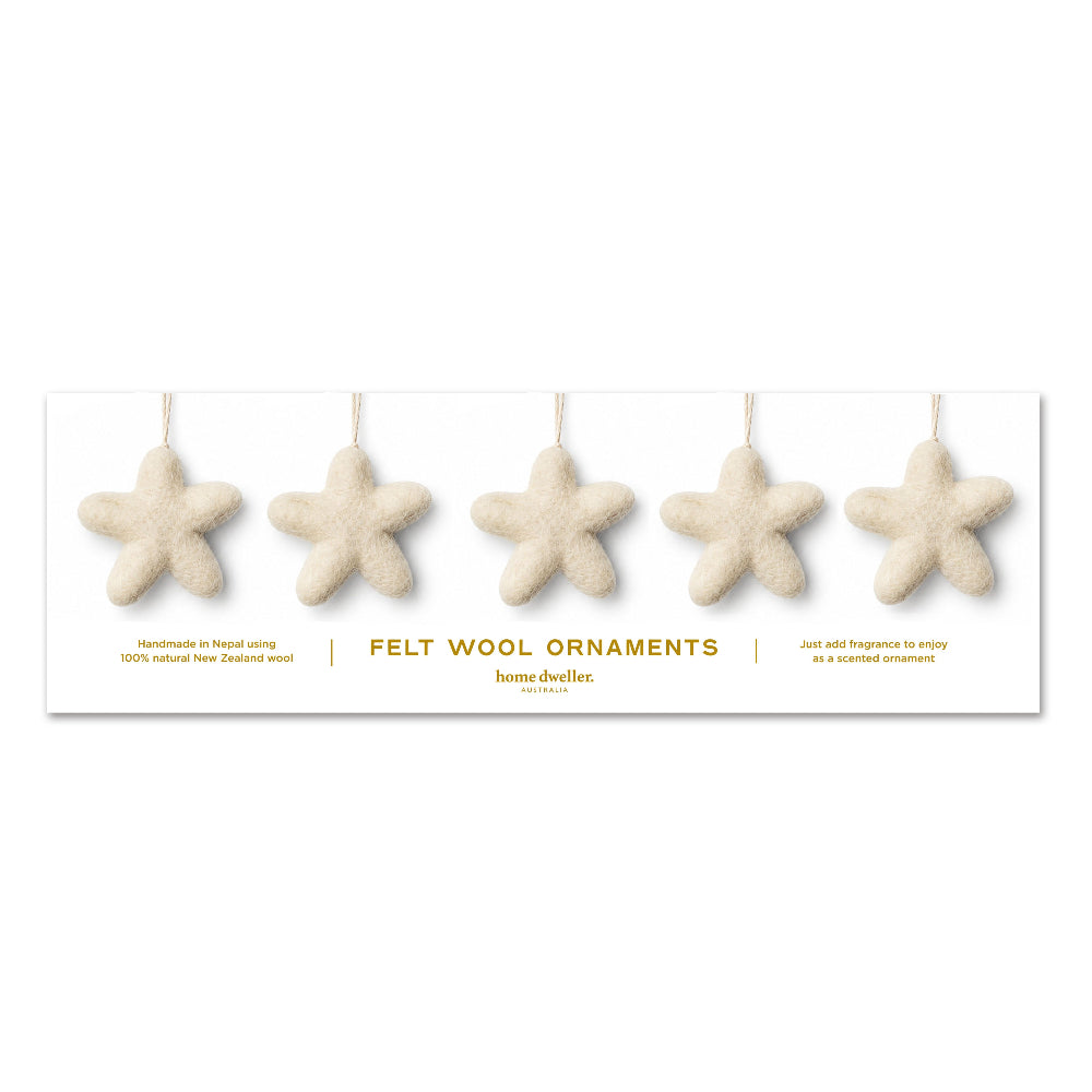 Five natural New Zealand wool starfish ornaments hanging from thin strings on a white display card with gold text, shown against a plain white background.