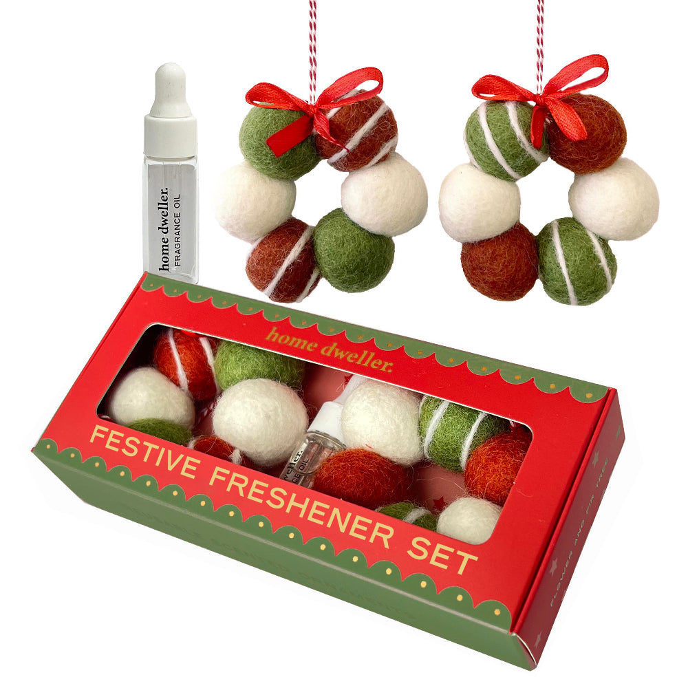 Home Dweller Festive Freshener Set featuring a red and green box containing felted wool holiday ornaments, a small white dropper bottle, and two hanging ornament clusters shown above the box on a white background.