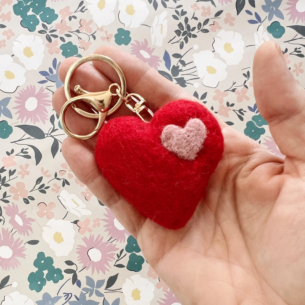 
                  
                    Wool felt heart keychain with gold clip in hand
                  
                