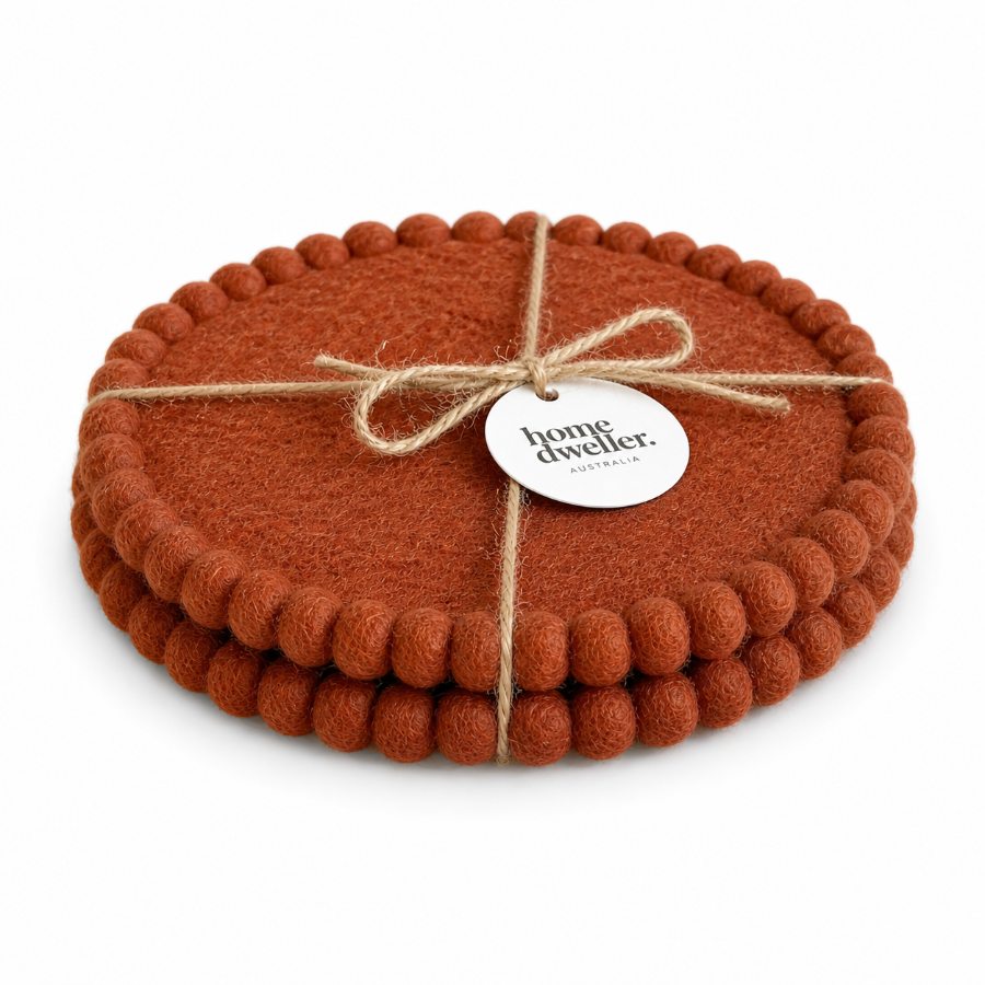 Set of brown trivets tied with twine and a 'home dweller' tag on a white background