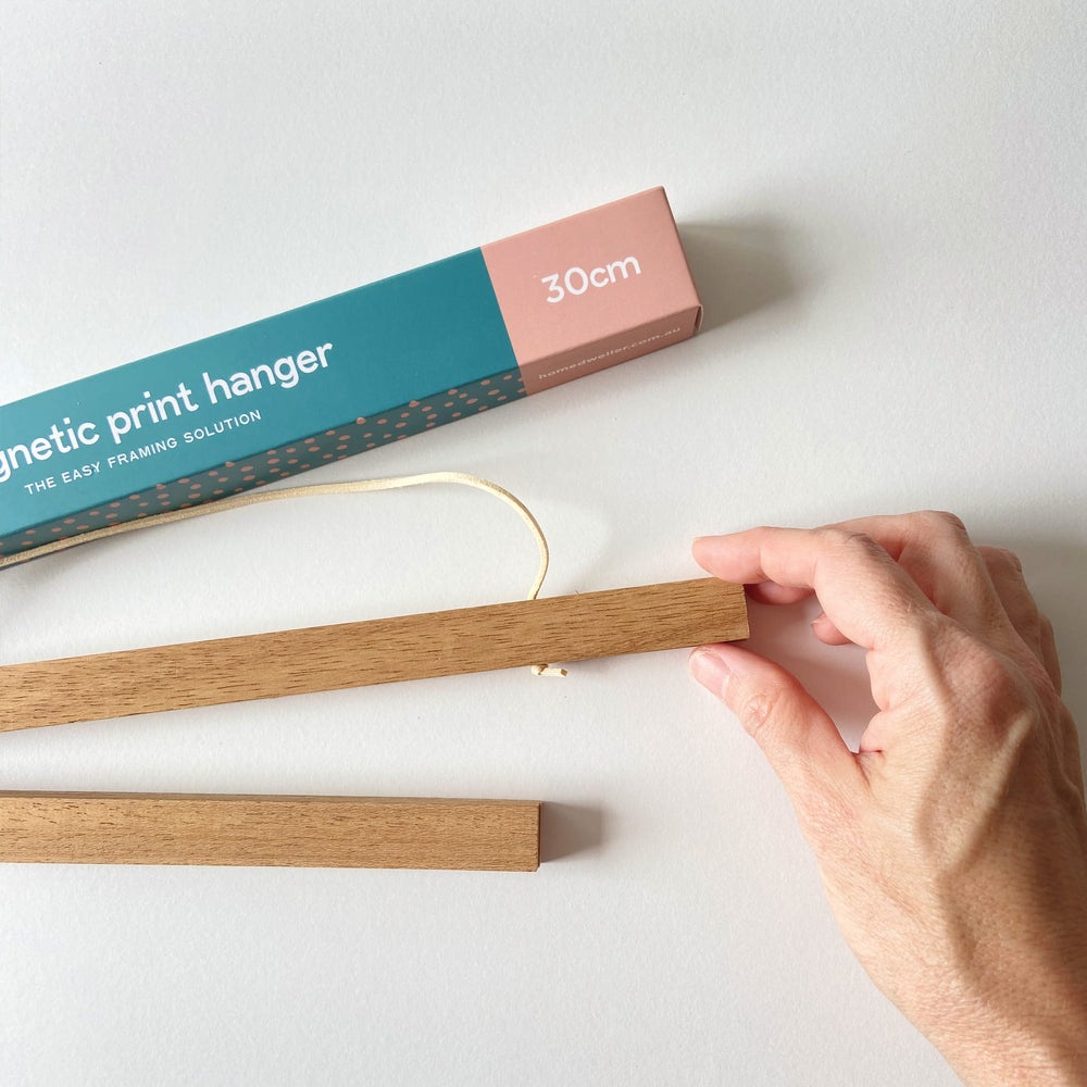 
                  
                    30cm Magnetic Print Hanger close up with hand
                  
                